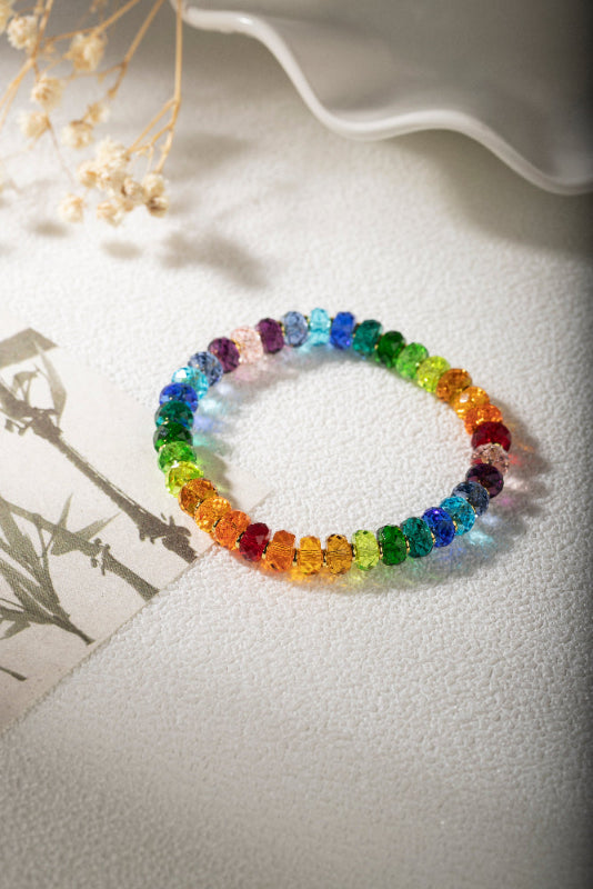 Multicolored beaded bracelet on a textured surface with a blurred background